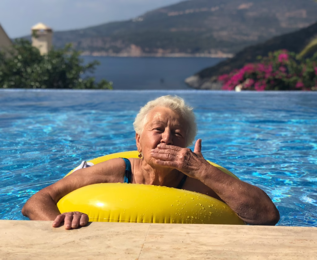 Confident over 60s woman blowing a kiss from a swimming pool