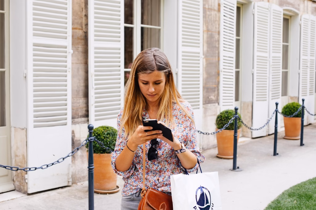 woman texting a friend as part of a calm arrival routine for solo women travellers in a new city